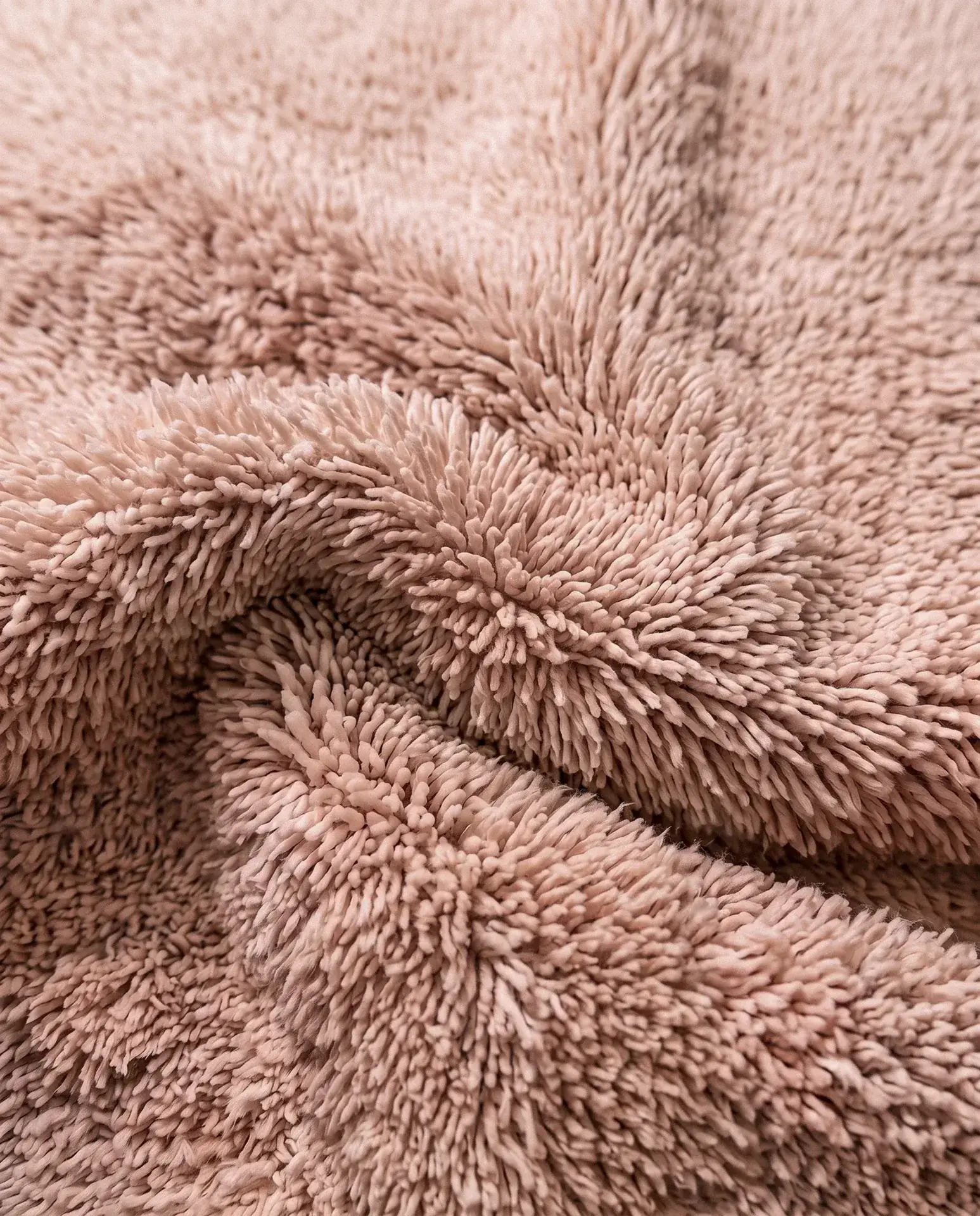 Close-up of the deep wool pile of a solid blush handmade Beni Ourain rug