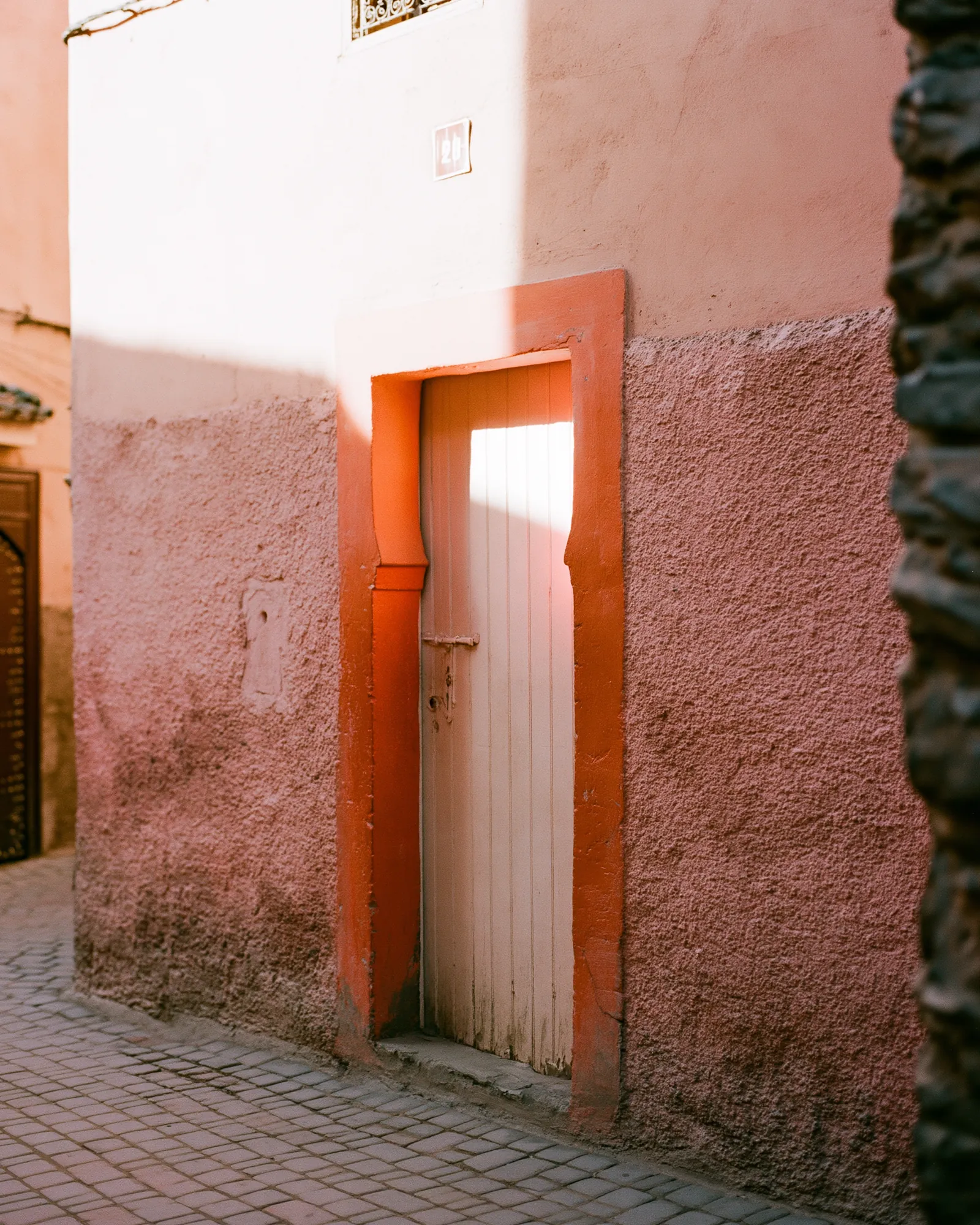 A medina door with a thin orange frame in a dusty-rose wall, the inspiration for the Borj Dusty Rose & Orange rug