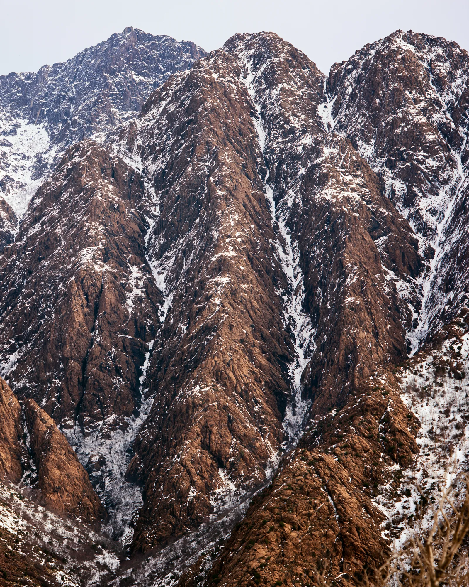 Brown rock ridges with snow lines in the gullies, the inspiration for the Tamda Charcoal & Ivory rug