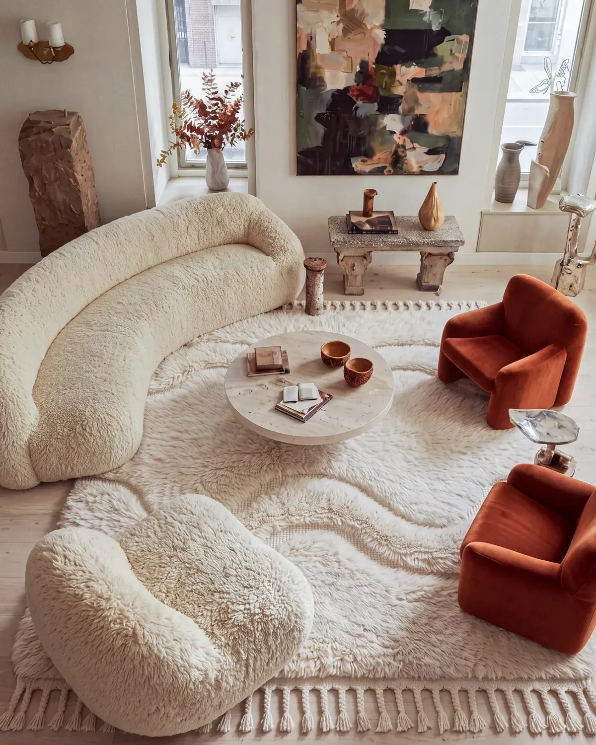 Dades Ivory hand-knotted Moroccan rug, in a living room between a boucle sofa and velvet chairs