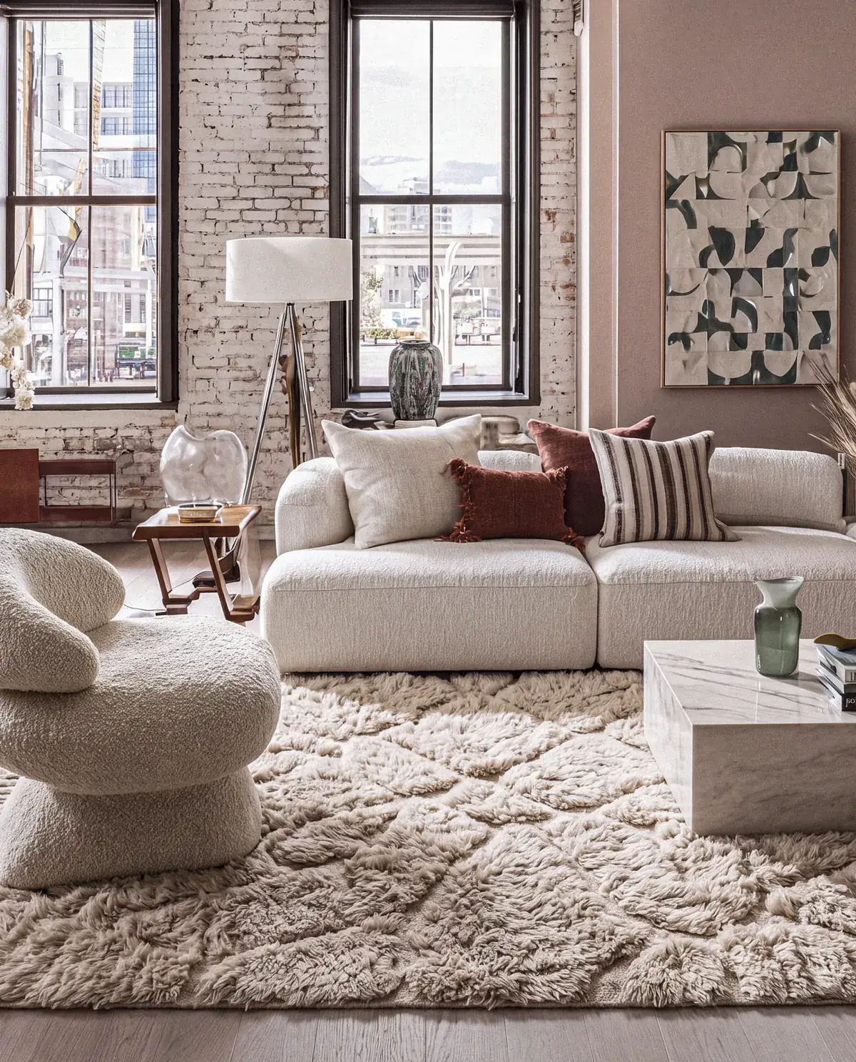 Akal Beige hand-knotted Beni Mrirt rug, carved lozenge lattice under an ivory boucle sofa in a brick loft