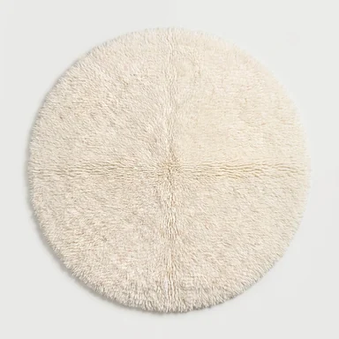 Solid ivory round hand-knotted wool rug flat lay