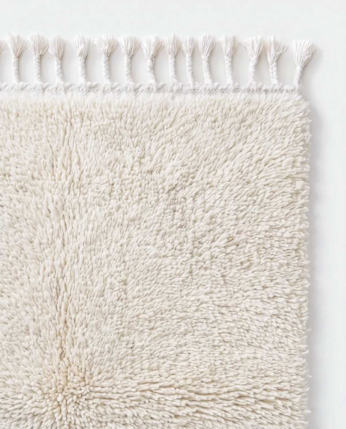 Close view of the undyed ivory wool pile of Tadelakt, a hand-knotted Beni Ourain rug