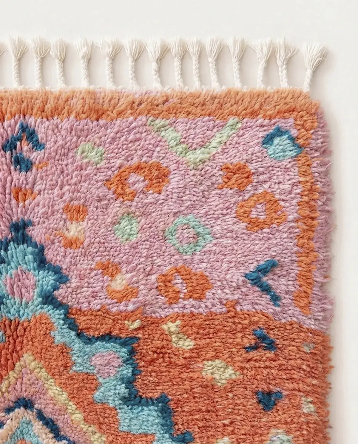 Close view of Zahra, a hand-knotted Boujaad rug in orange, pink and teal wool